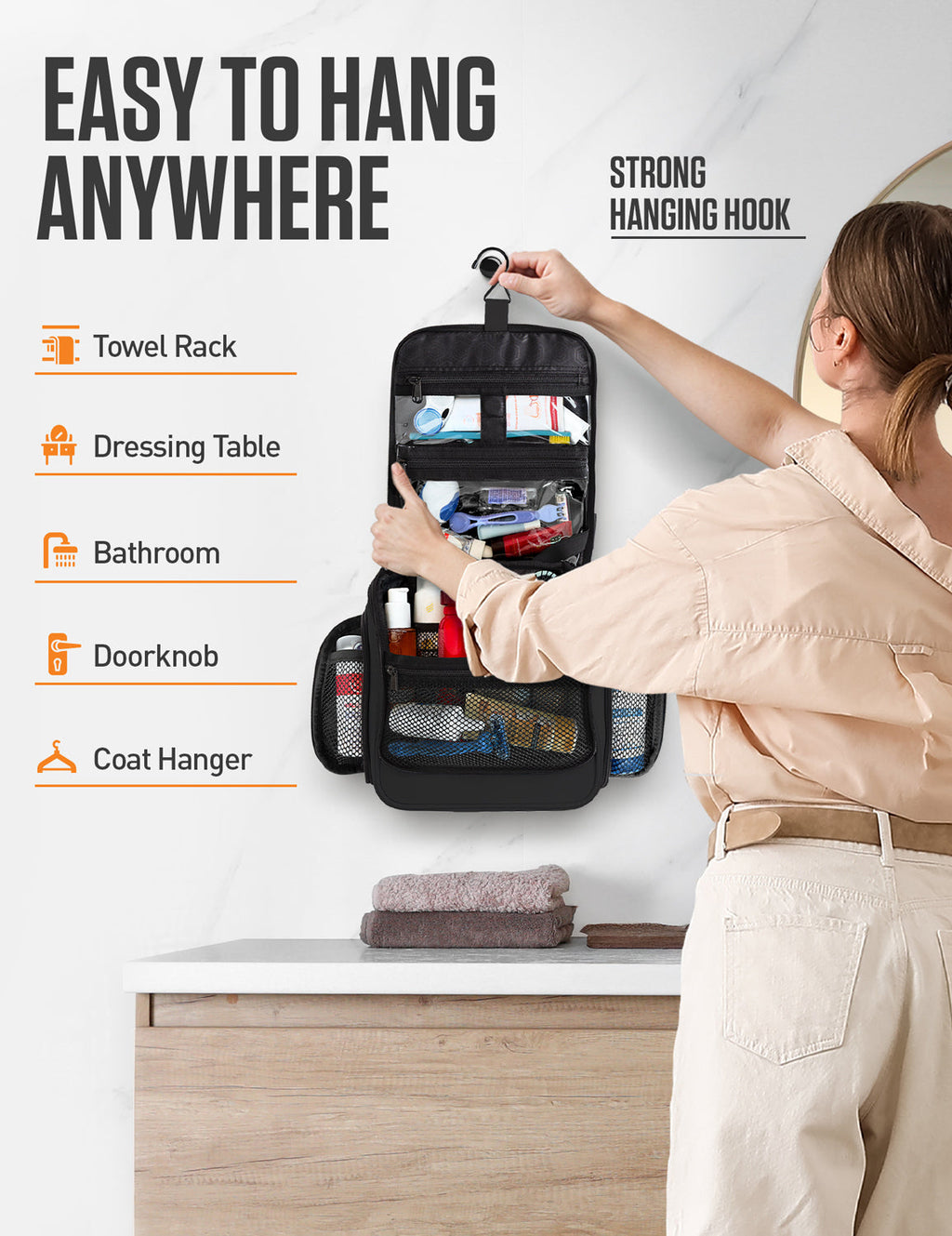 Person hanging an open black toiletry bag above a bathroom counter using its hook.