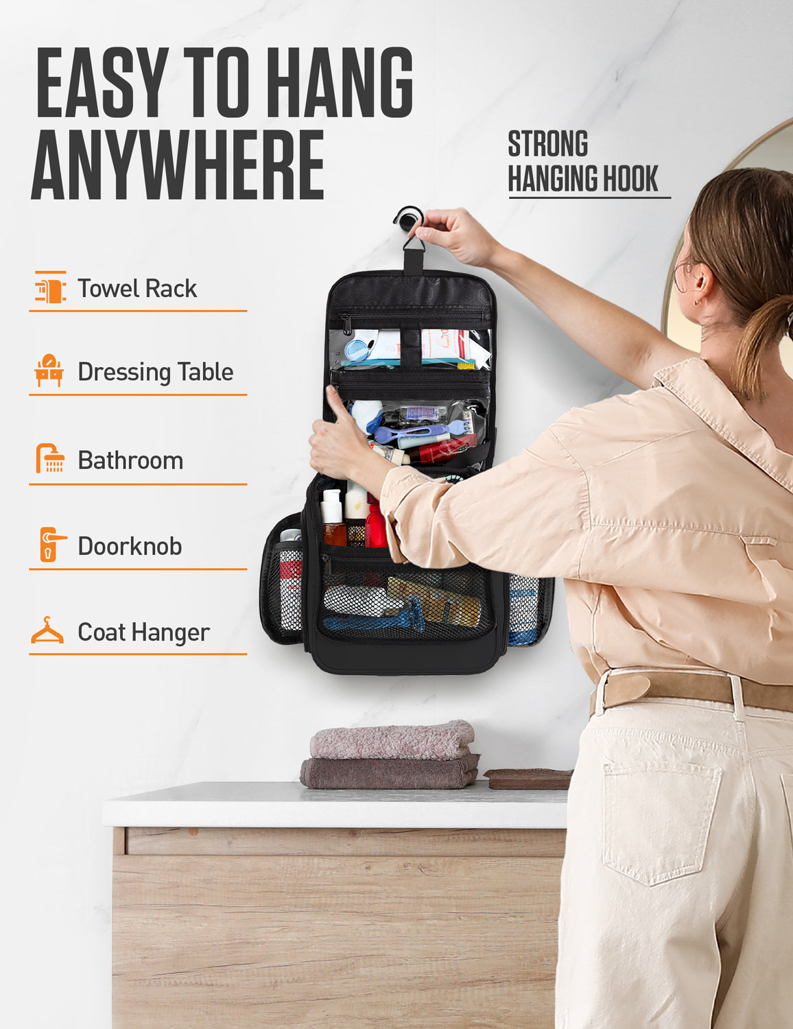 Person hanging an open black toiletry bag above a bathroom counter using its hook.